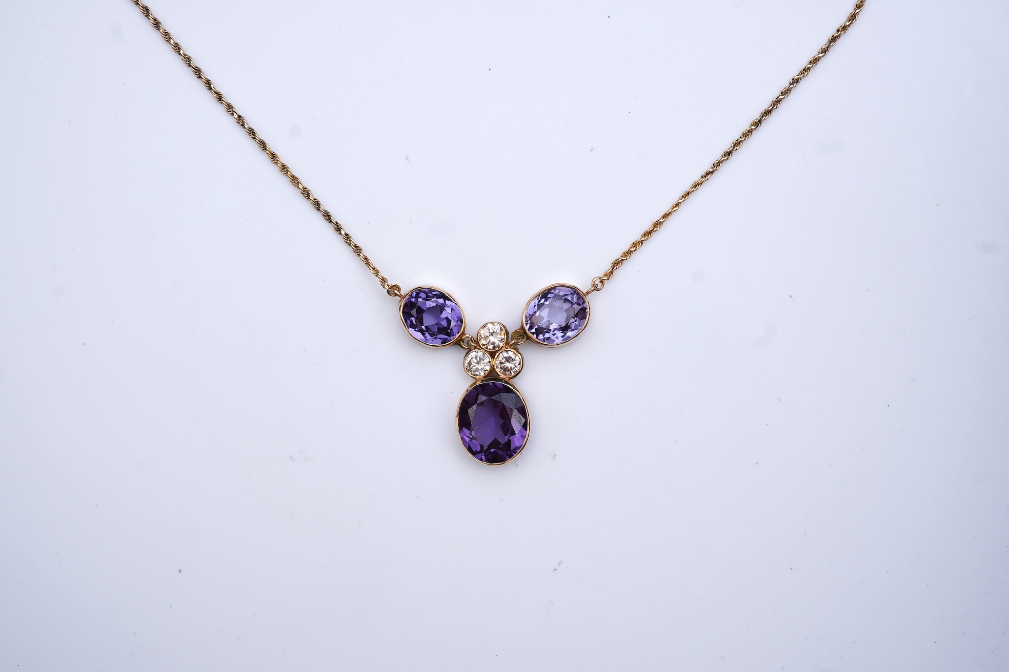 A synthetic colour-change sapphire and diamond pendant necklace